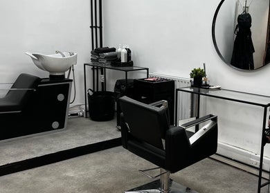 Modern salon station at SK & Co Salon in Hatfield, England, GB, featuring sleek black and white decor.