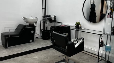 Modern salon station at SK & Co Salon in Hatfield, England, GB, featuring sleek black and white decor.
