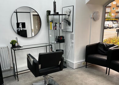 Modern salon interior at SK & Co Salon, Hatfield, England, GB with styling chair and large mirror.