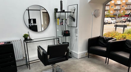 Modern salon interior at SK & Co Salon, Hatfield, England, GB with styling chair and large mirror.