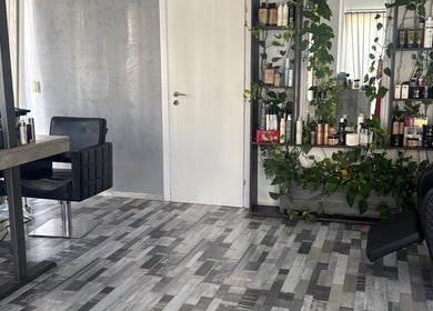 Modern interior of Bouma hair boutique, Nicosia, Lefkosia, CY, featuring sleek decor and lush greenery.