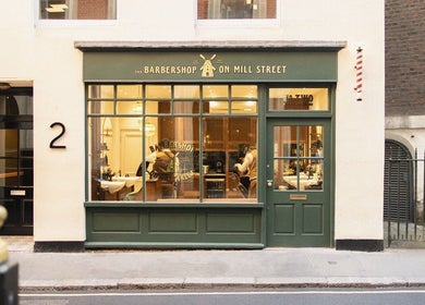 Exterior view of The Barbershop On Mill Street in London, England, GB, showcasing its inviting green facade.