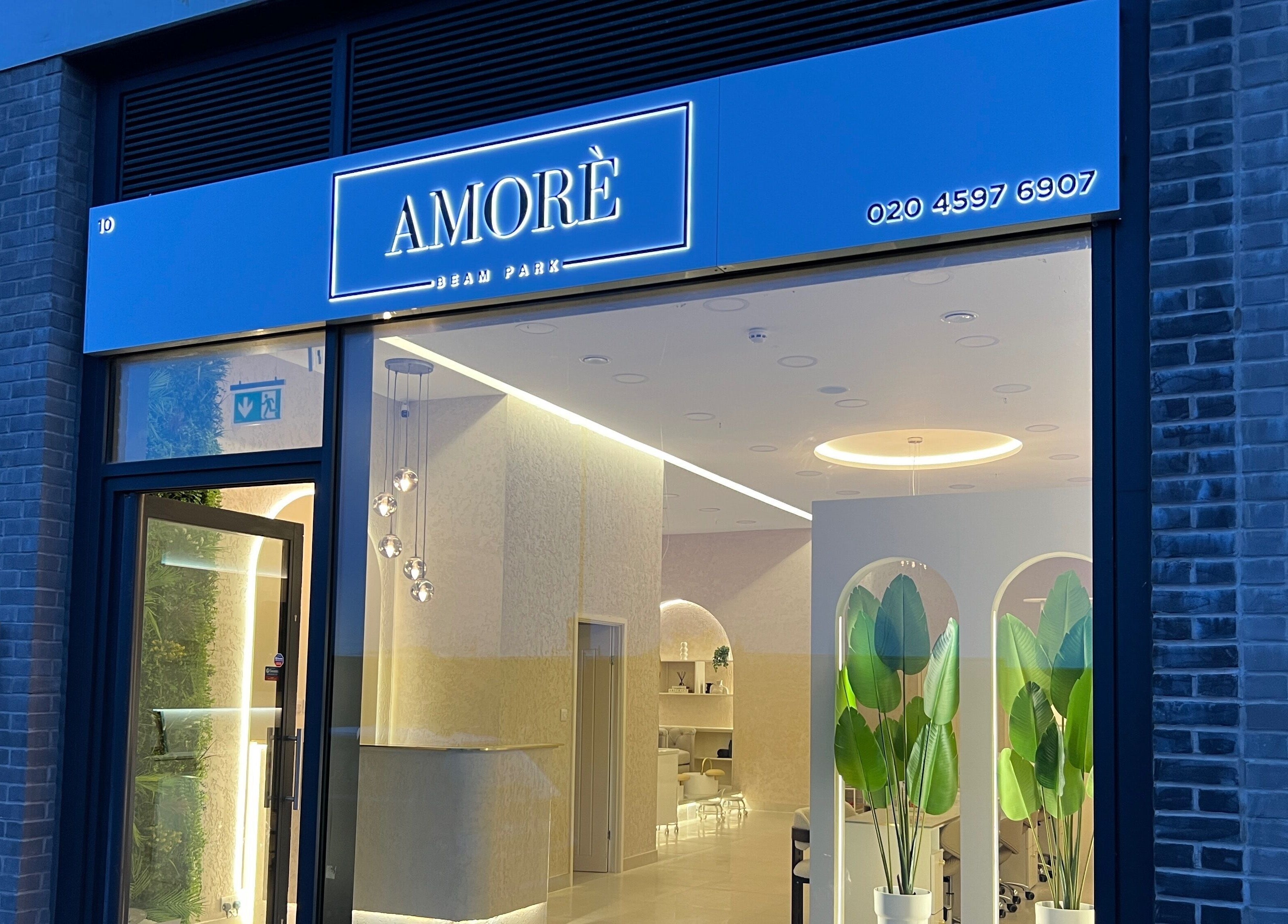 Exterior view of Amore Beam Park, a beauty venue in Rainham, England, GB with modern entrance and elegant lighting.