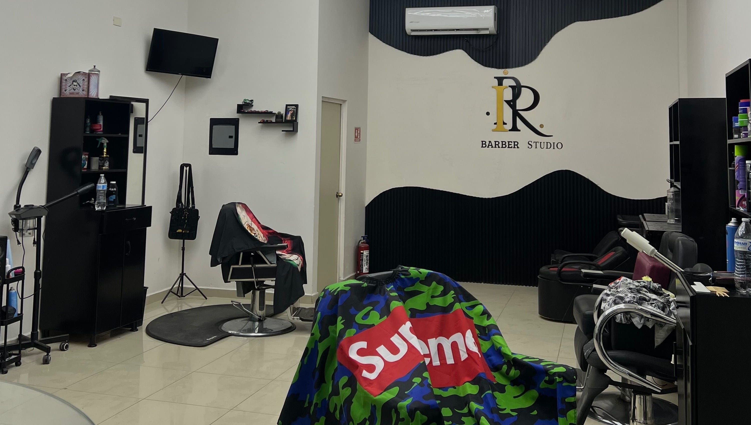Vista interior de IPR BARBER STUDIO en Guaymas, Sonora, MX con sillas y decoración moderna.