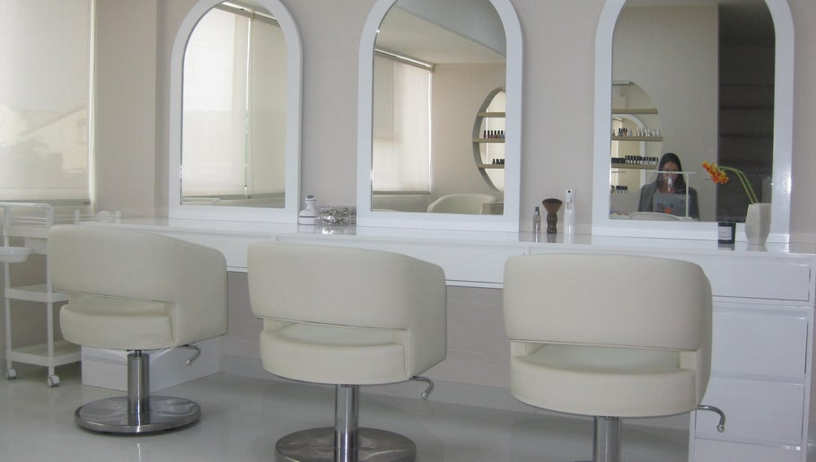 Interior de Anelle Beauty Studio en San Isidro. Espejos y sillas blancas destacan el diseño moderno y elegante.