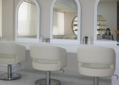 Interior de Anelle Beauty Studio en San Isidro. Espejos y sillas blancas destacan el diseño moderno y elegante.