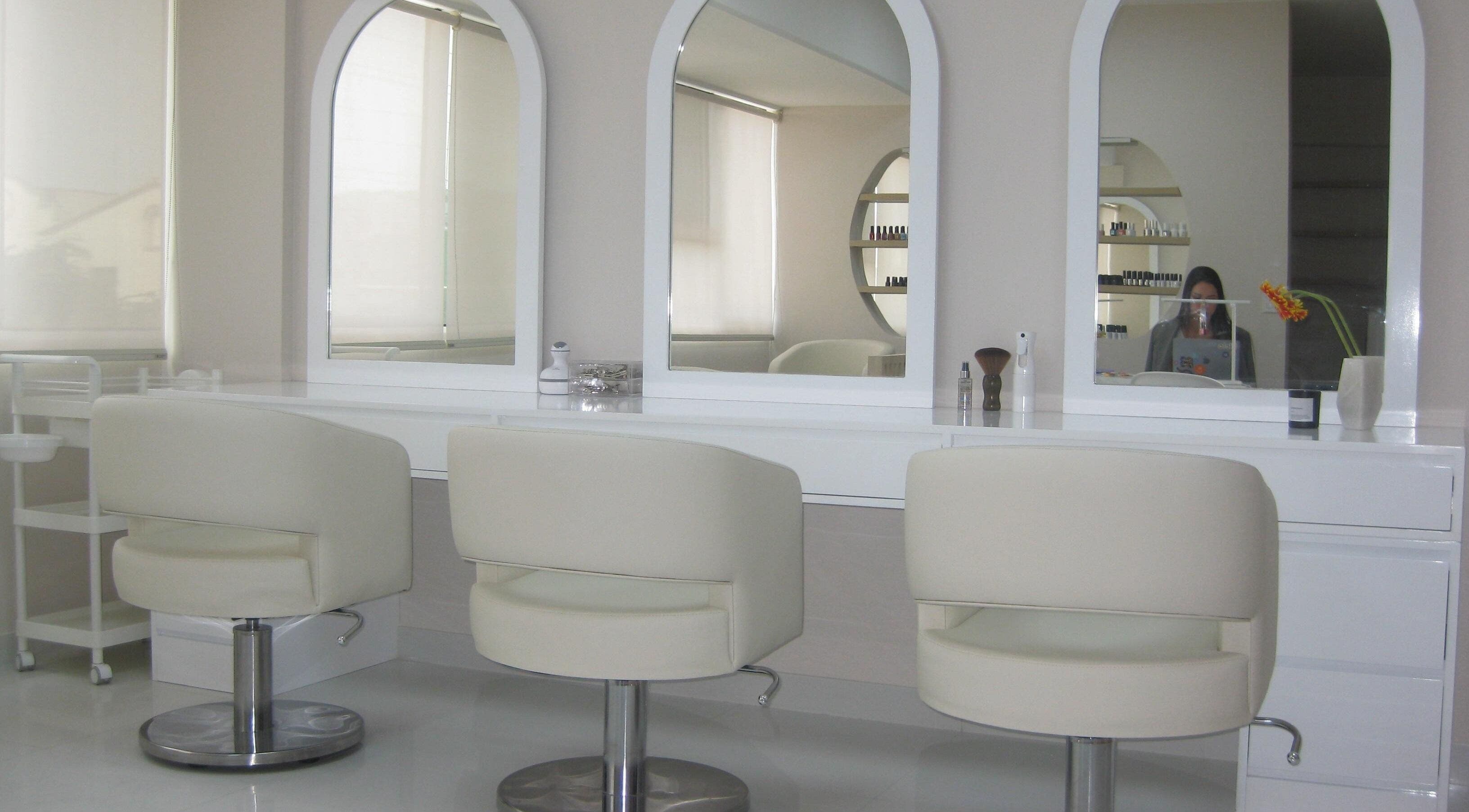 Interior de Anelle Beauty Studio en San Isidro. Espejos y sillas blancas destacan el diseño moderno y elegante.