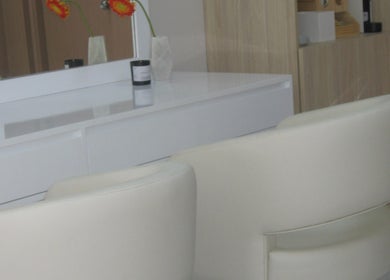 Interior de Anelle Beauty Studio en San Isidro, Provincia De Lima, PE, con sillas blancas junto a tocador.