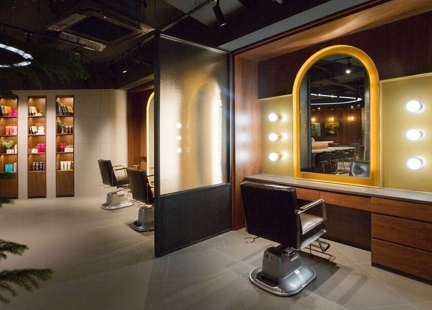 Interior of JUNO HAIR Gangnam Woosung Branch, Seoul, featuring stylish salon chairs and mirrored lights.