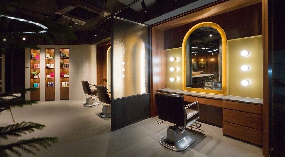 Interior of JUNO HAIR Gangnam Woosung Branch, Seoul, featuring stylish salon chairs and mirrored lights.