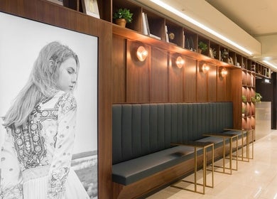 Modern seating and art at JUNO HAIR Gangnam Woosung Branch, Seoul, enhancing the welcoming atmosphere.