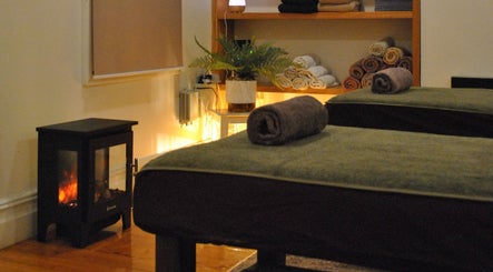 Relaxing massage room at Yarraville Massage, Melbourne, Victoria, AU with warm lighting and rolled towels.