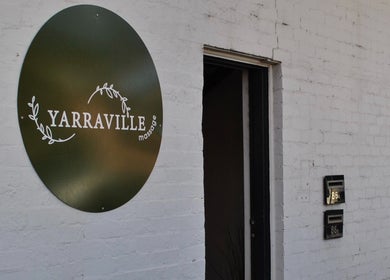 Elegant entry sign of Yarraville Massage in Melbourne, Victoria, AU, set against a white brick wall.