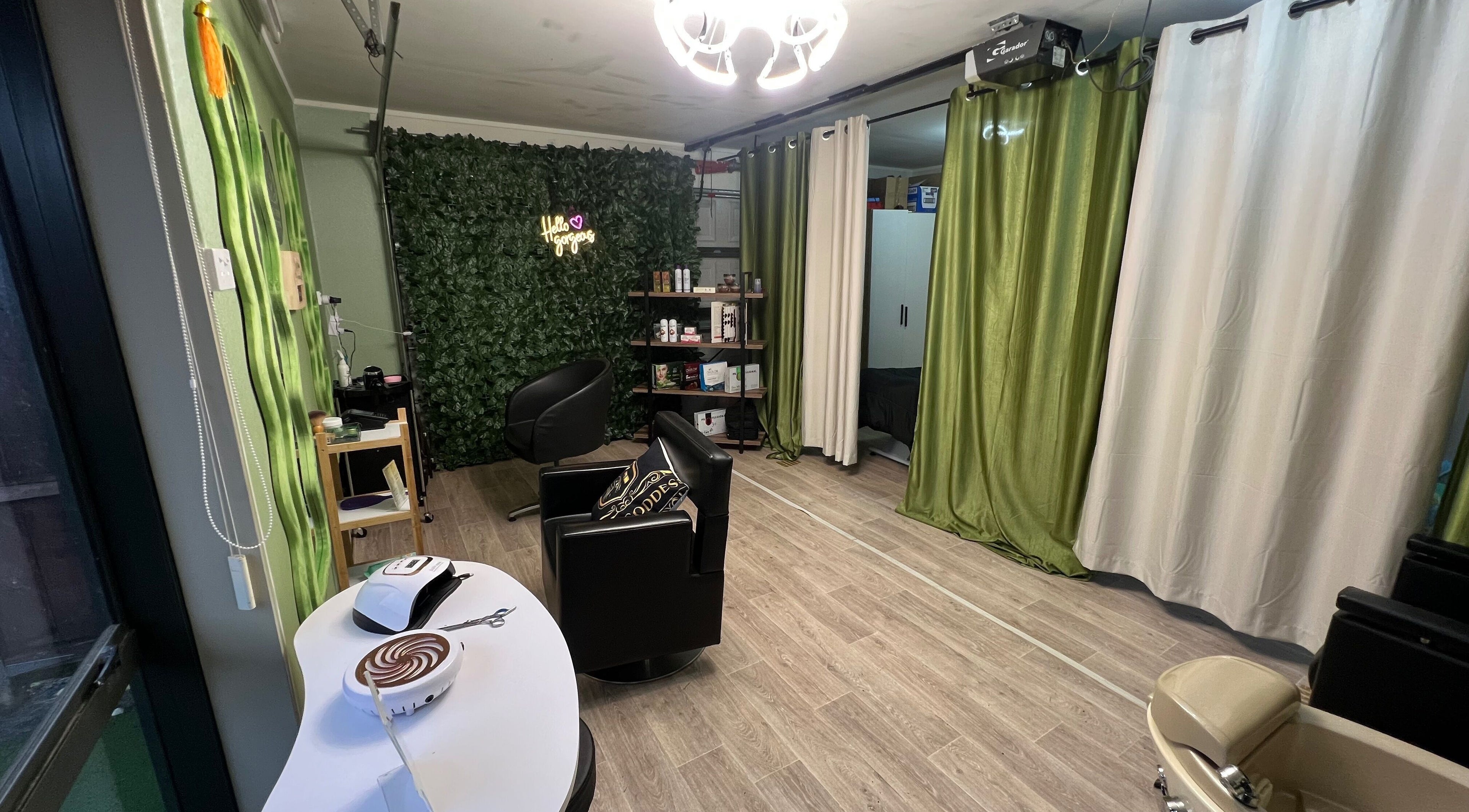 Interior view of Glam Goddess Beauty & Hair Salon in Auckland, NZ, showcasing stylish chairs and lush green decor.