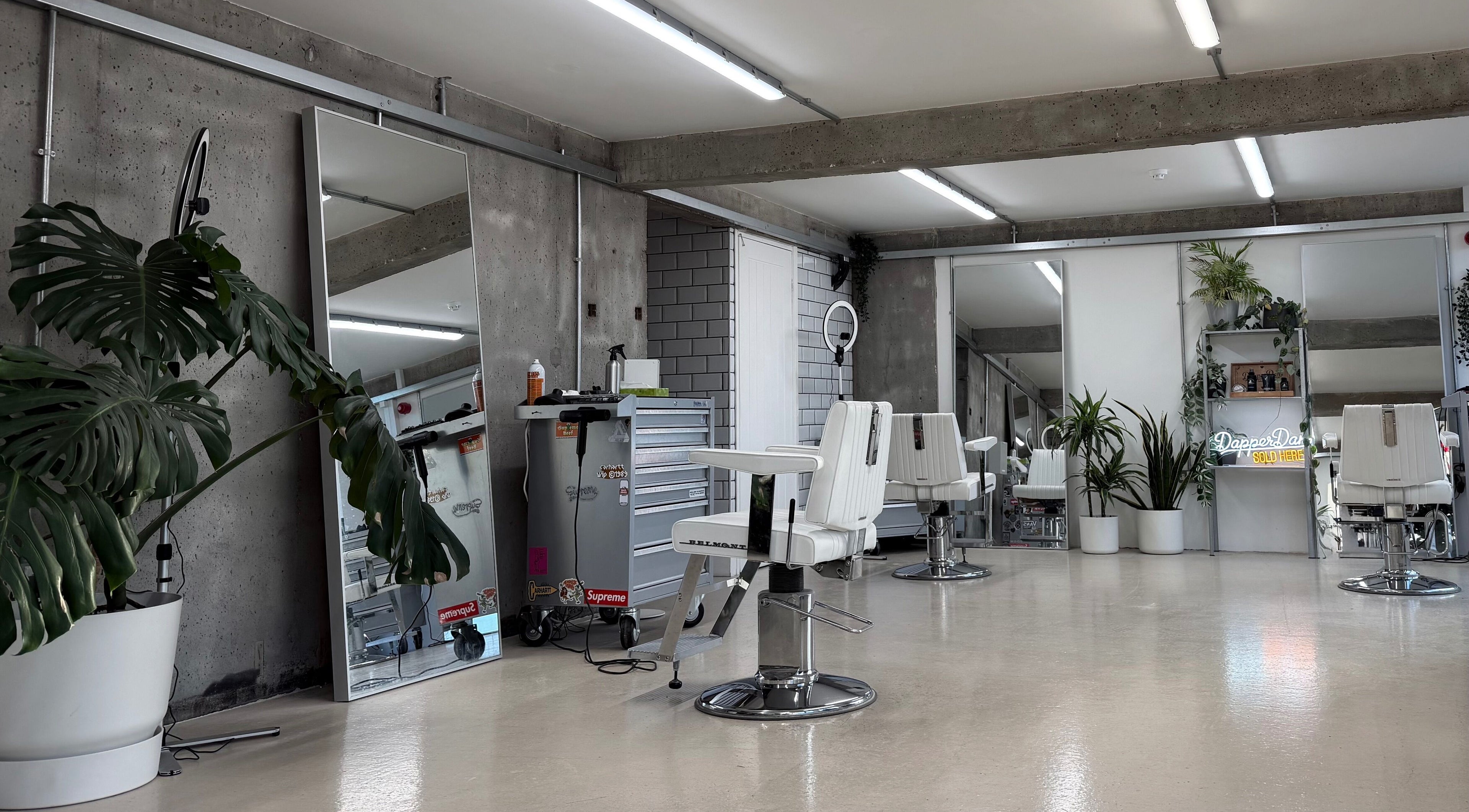 Modern interior of Nine Lives Barbershop in Sheffield, England, GB with sleek chairs and stylish decor.