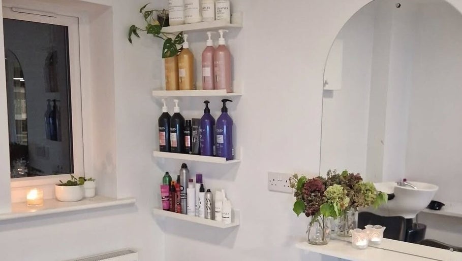 Elegant shelves with hair products at Hannah Hairdressing in Penketh, England, GB. Modern and inviting salon space.