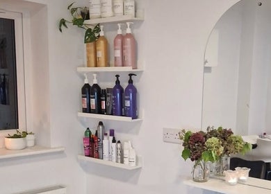 Elegant shelves with hair products at Hannah Hairdressing in Penketh, England, GB. Modern and inviting salon space.
