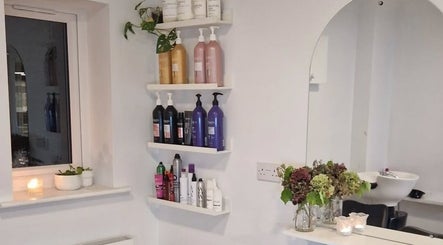 Elegant shelves with hair products at Hannah Hairdressing in Penketh, England, GB. Modern and inviting salon space.