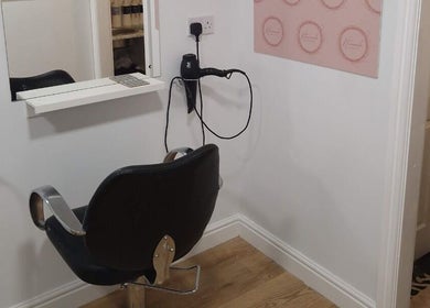 Modern styling station at Hannah Hairdressing in Penketh, England, GB, featuring a sleek chair and mirror.