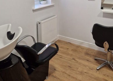 Cozy hairdressing salon corner at Hannah Hairdressing in Penketh, England, GB with modern styling chairs and wash basin.