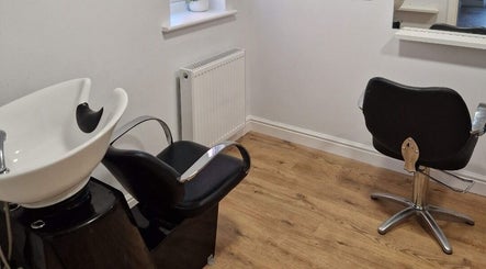 Cozy hairdressing salon corner at Hannah Hairdressing in Penketh, England, GB with modern styling chairs and wash basin.
