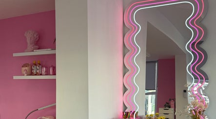 Vibrant pink and neon mirror at Nails With Soph, Eastbourne, England, GB. Modern decor enhances salon ambiance.