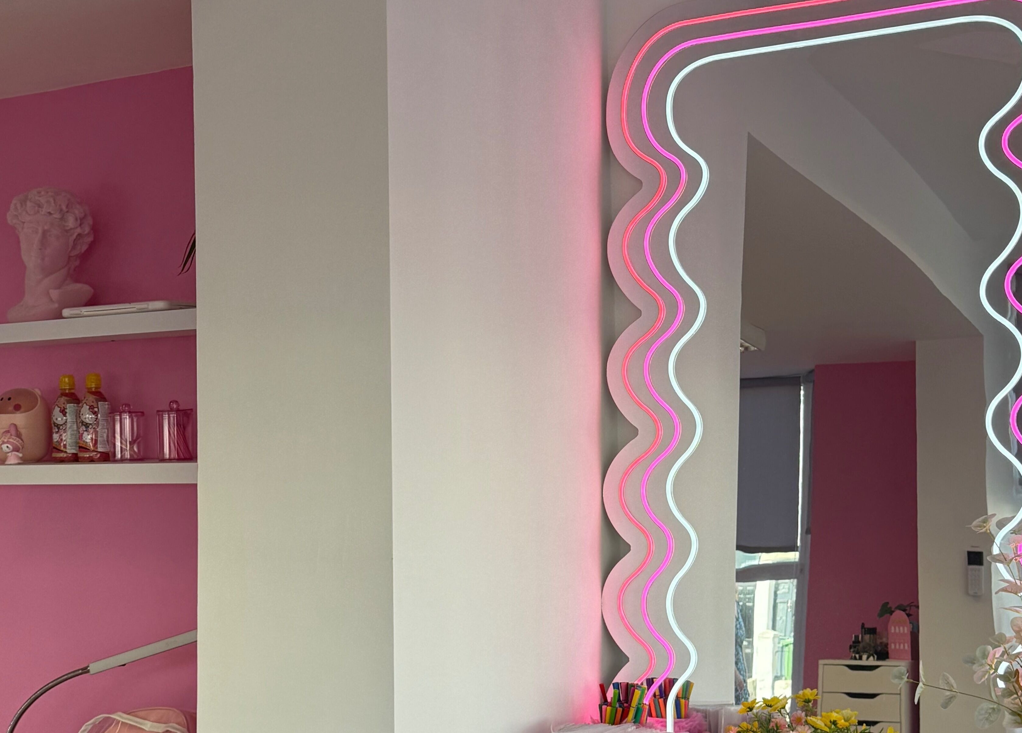 Modern neon mirror at Nails With Soph, Eastbourne, England, GB, enhancing the vibrant salon decor.