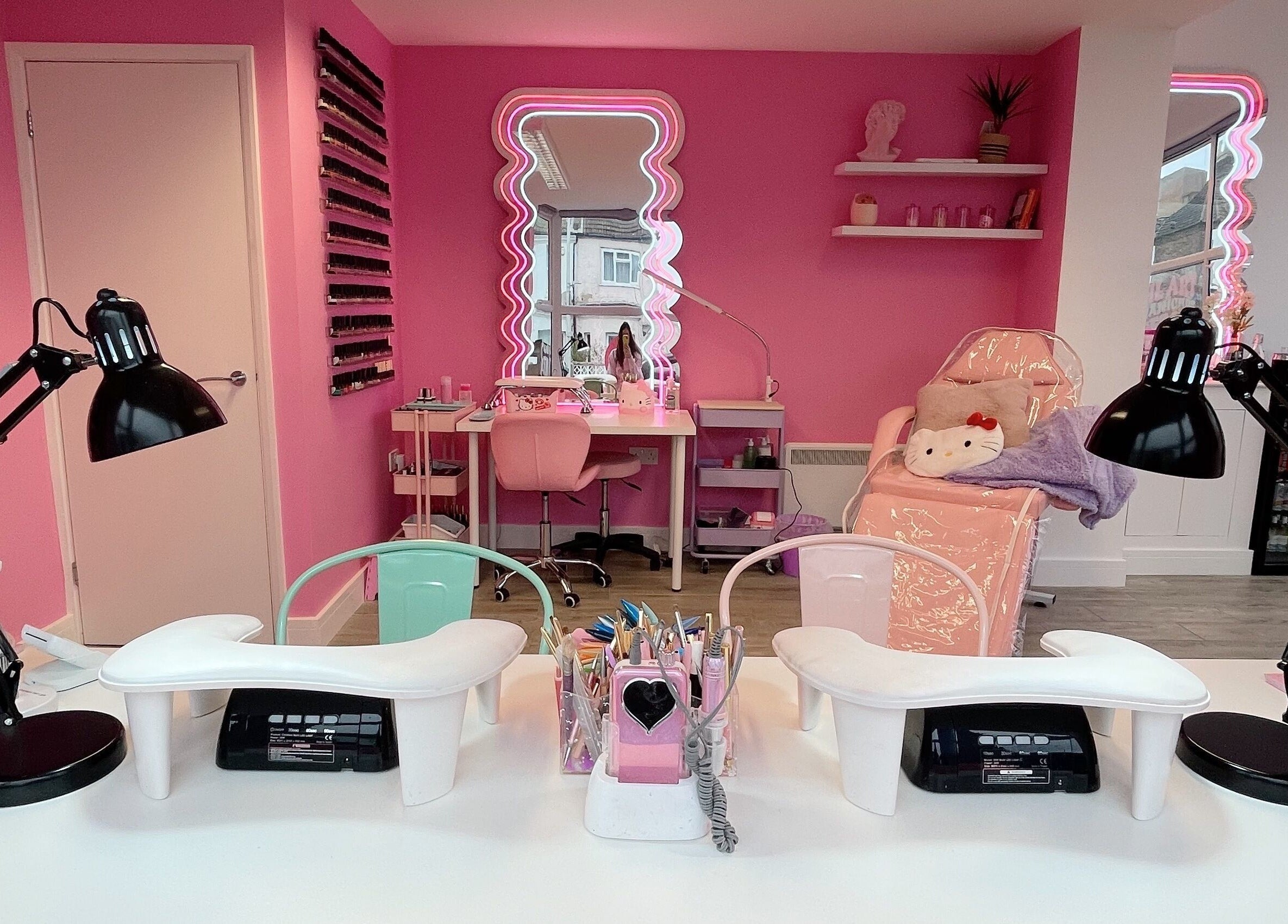 Bright pink nail studio at Nails With Soph in Eastbourne, England, GB features modern decor and stylish workstations.