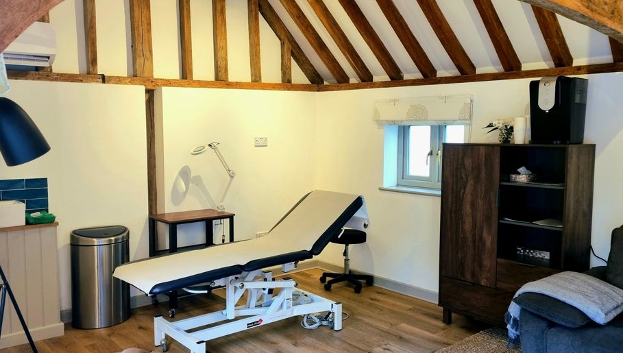 Cozy treatment room at Georgina Holly Aesthetics, Betchworth, England, GB, showcasing a rustic, inviting setting.