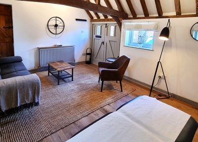 Cozy rustic room at Georgina Holly Aesthetics, Betchworth, England, GB with seating and decor.