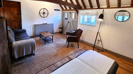 Cozy rustic room at Georgina Holly Aesthetics, Betchworth, England, GB with seating and decor.