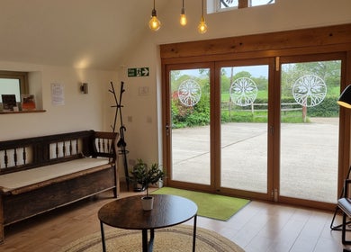Charming lounge at Georgina Holly Aesthetics, Betchworth, England, featuring cozy seating and natural light.
