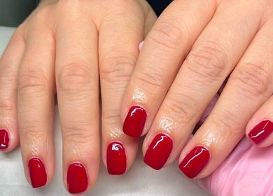 Glossy red manicured nails at Ems Beauty in Stockport, England, GB, showcasing professional nail care.