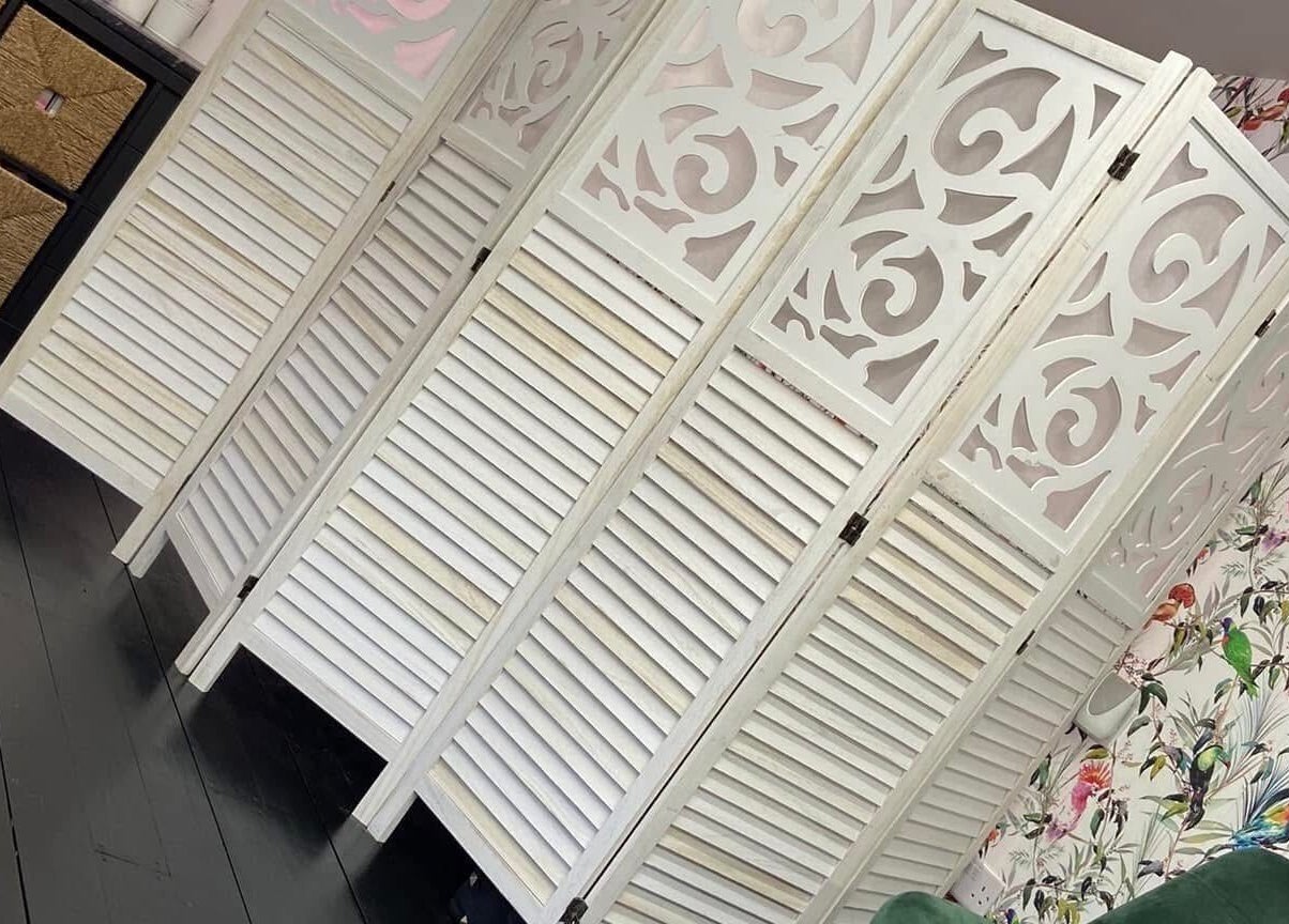 Ornate white panel divider in Fluff n Flutter, Mansfield, England, GB, with vibrant floral wallpaper.