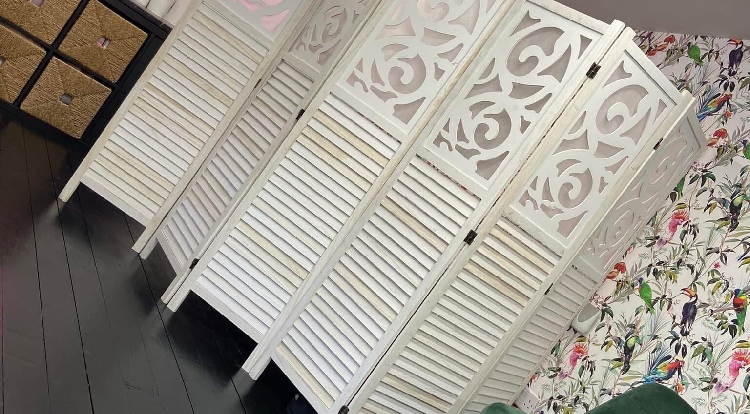 Ornate white panel divider in Fluff n Flutter, Mansfield, England, GB, with vibrant floral wallpaper.