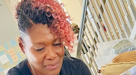Stylist with vibrant curly hair at The Purple Door Styling & Grooming Lounge, Spartanburg, South Carolina, US.