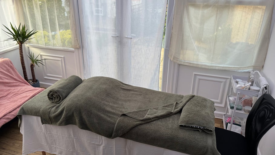 Relaxing massage bed setup at Mia Wellness Room in Penryn, England, GB, bathed in natural light.