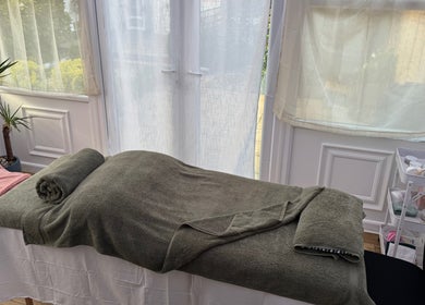 Relaxing massage bed setup at Mia Wellness Room in Penryn, England, GB, bathed in natural light.
