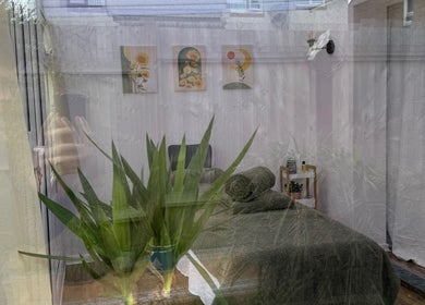 Elegant spa room at Mia Wellness Room in Penryn, England with lush plants and soothing decor.