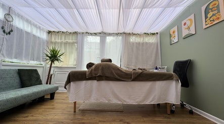 Tranquil massage room at Mia Wellness Room, Penryn, England, GB with serene decor and lush greenery.