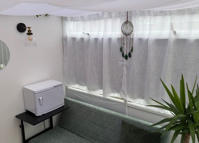 Relaxing corner in Mia Wellness Room, Penryn, England, GB with sofa, plant, and soft lighting.