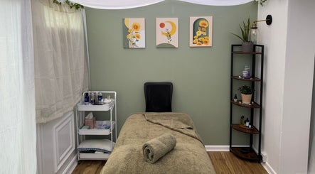 Serene massage room at Mia Wellness Room, Penryn, England, GB with calming green walls and subtle decor.