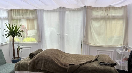 Calm treatment room at Mia Wellness Room, Penryn, England, GB with a massage table and soothing decor.