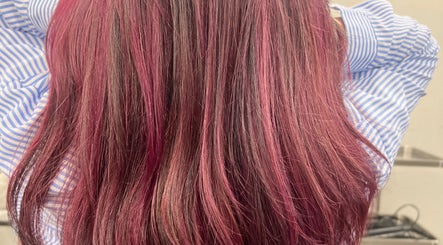 Vibrant pink-red hair expertly styled at D_A hair Design, London, England, GB.