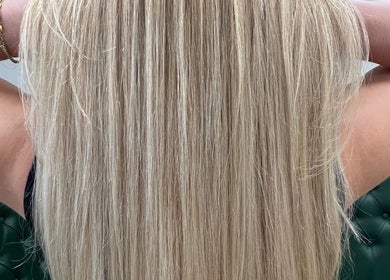 Long blonde hair styled at D_A hair Design in London, England, GB, showcasing sleek texture.
