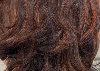 Elegant dark brown hair with highlights at D_A hair Design in London, England, GB.