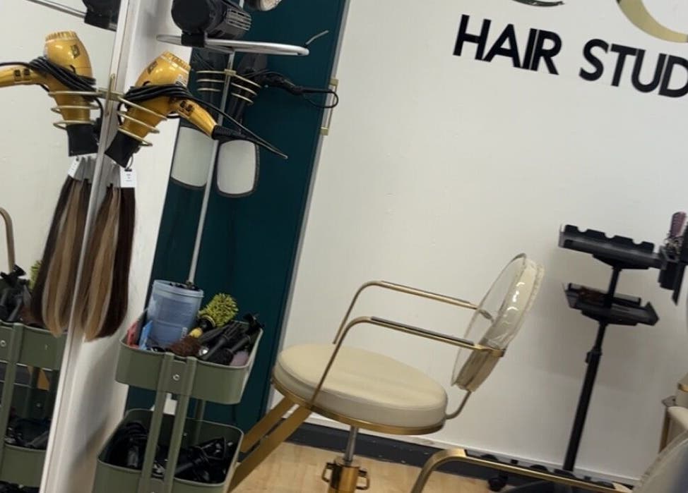 Modern salon interior at Keratin by Anais in London, England, GB, showcasing stylish chairs and hair drying tools.