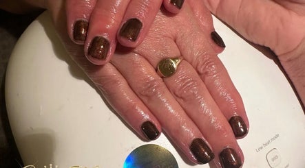 Shiny brown manicure at Cece Mol Beauty, York, England, GB. Hands rest under LED lamp.