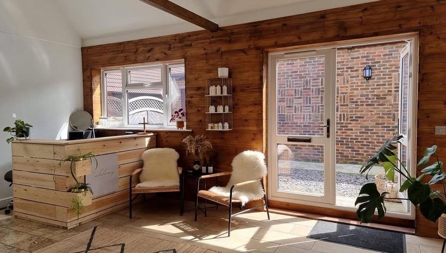 Warm wooden interior of B L The Hair Collective in Hastings, England, GB, showcasing a serene waiting area.