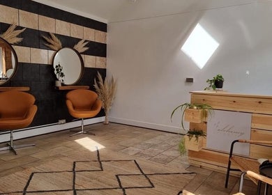 Stylish salon interior at B L The Hair Collective, Hastings, England, GB featuring modern decor and cozy seating.